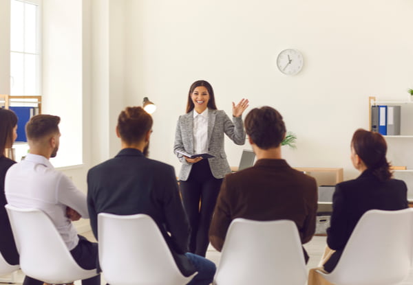 Team leader greeting workers in corporate meeting