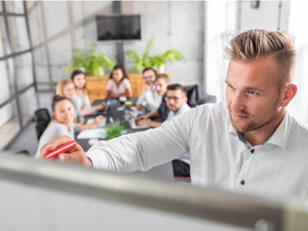 Team leader teaches employees at a business meeting in a conference room