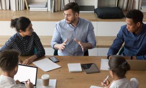 Male manager talk to diverse business people at group meeting